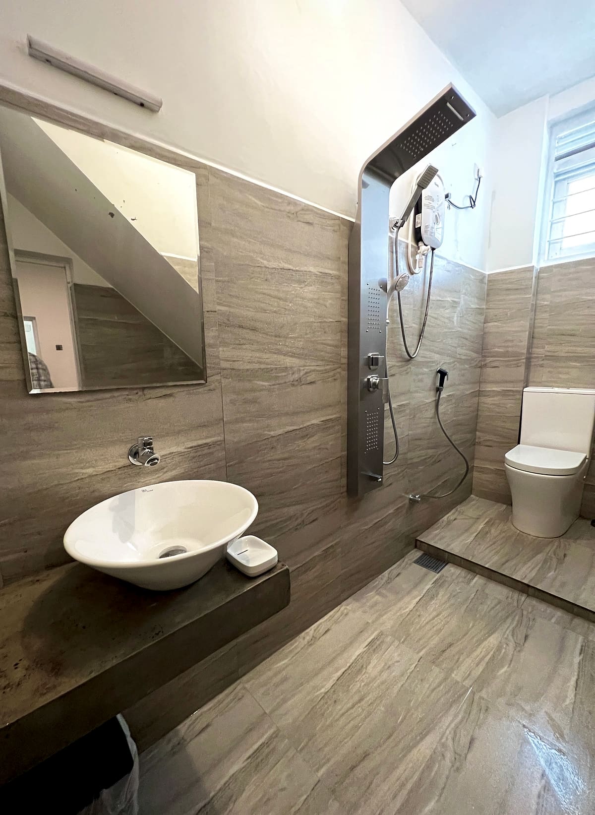 A modern DELMOND Lake bathroom with vessel basin and rain shower panel
