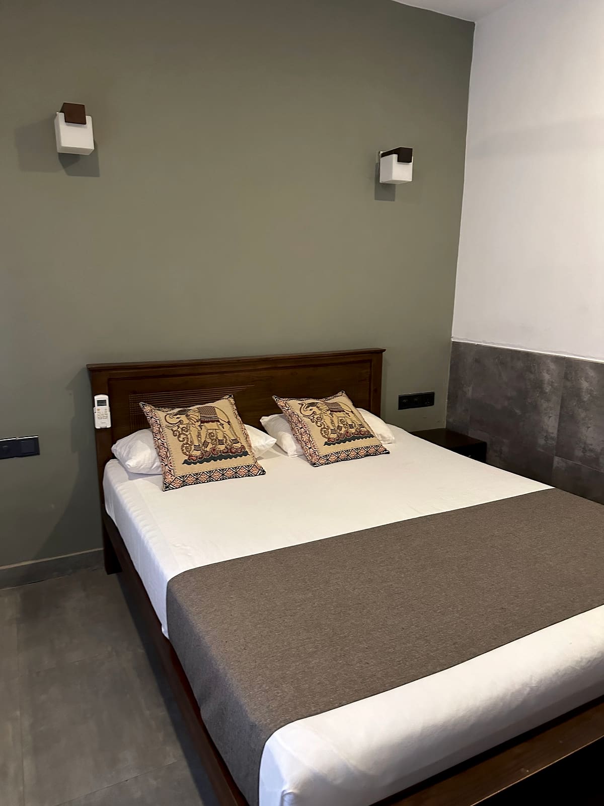 Double bed with crisp white linen, grey runner and patterned cushions in a grey-walled room at DELMOND Lake